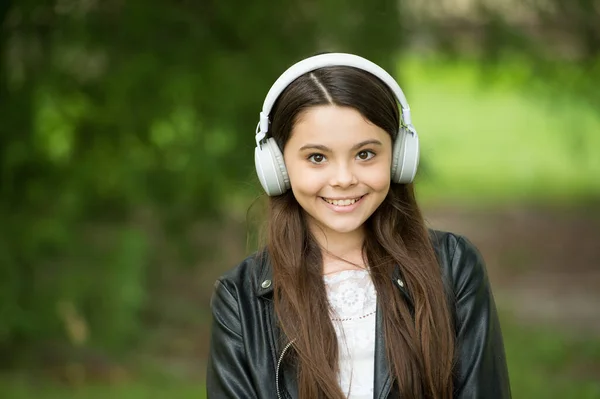ヒップスターの女の子は音楽を聞いて現代のヘッドフォンの性質の背景、オーディオブックコンセプト — ストック写真