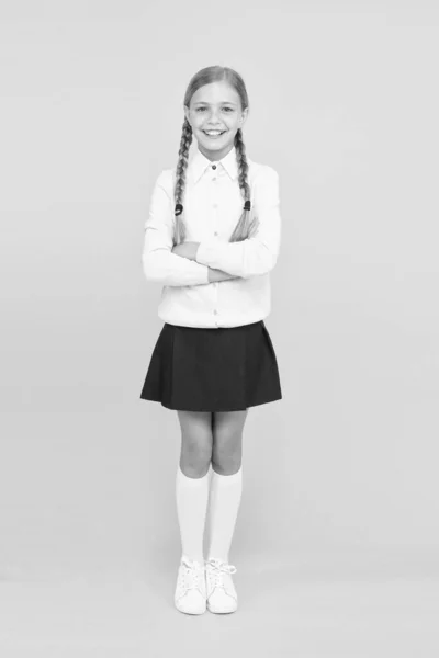 Magabiztos diákok. tudásnap. Gyerekkori boldogság. Boldog lány iskolai egyenruhában. oktatási koncepció. Vissza az iskolába. Kölyök divat. Iskolapiac. okos kislány sárga háttér — Stock Fotó