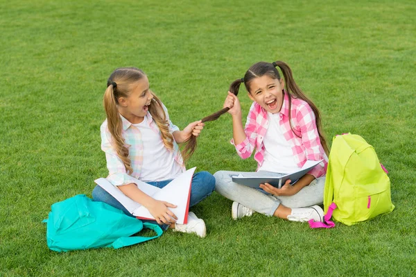 Alunos de escola de meninas fazendo lição de casa juntos no ar fresco, conceito de crianças brincalhão — Fotografia de Stock
