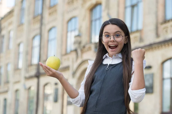 Hou je energieniveau op peil. Gelukkig kind houdt appel op open hand. Een schoolsnack. Gezondheidsonderwijs. Energiedieet. Voedsel met weinig voedingsenergie. Gezonde voeding volgen — Stockfoto