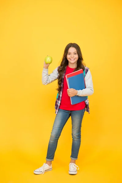 Zdravá svačinka. Šťastné dítě drží jablka a knihy. Školní svačinka. Pauza na svačinu. Zdravé jídlo a svačina. Vegetariánské jídlo. Vitaminová výživa. Dieta a dieta. Snídaně nebo oběd. Jíst vpravo — Stock fotografie