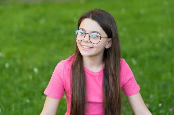 Bambina indossare occhiali da vista bordo vintage verde prato sfondo, concetto di aria fresca — Foto Stock