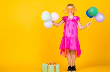 Güzel bir tatil partisi. Çocuk eğleniyor. Uluslararası Çocuk Günü. Mutlu çocukluk. Balonlu küçük çocuk. Entertainment doğum günü konsepti. Çocuk balonlarla ve hediye kutusuyla parti veriyor.