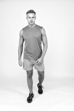 Tüm kaslarını çalıştır. Kaslı adam sarı arka plan. Spor giyim sektöründe formda bir sporcu. Kaslı bir sporcu. Kaslı bir tip. Kas gücü ve gücü eğitiyorum. Spor ve spor