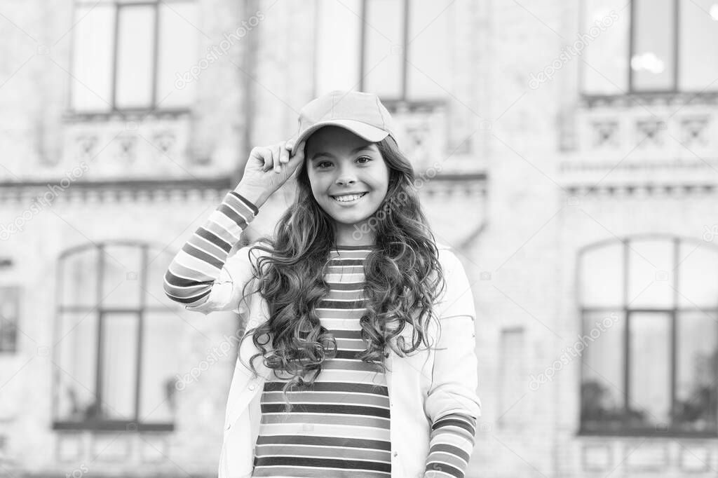 Child smiling outdoors. Beauty and fashion. You would not know anything unless you try. Schoolgirl wear cap. Teen in casual style and cap. Childhood happiness. Happy girl with curly hair wearing cap