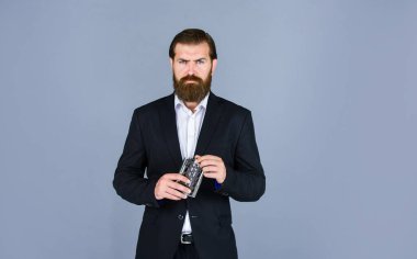 Viski için kalça matarası. Klasik erkek hediyelik eşya dükkanı. İçki içen acımasız bir iş adamı. Elinde içki şişesi olan adam. Adam rahatlarken demir mataradan sert alkol içiyor.