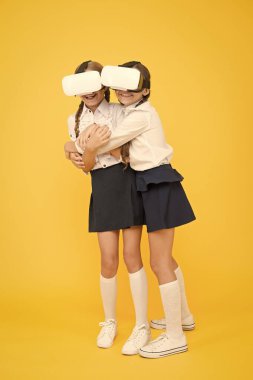 VR teknolojileri. Mutlu çocuklar modern teknolojiyi kullanır. Çocuklar kablosuz sanal gerçeklik gözlüğü takıyor. Sanal gerçeklik. VR kulaklıklı küçük kızlar. Gelecekteki eğitim. Okula dönüyorum. Dijital gelecek ve yenilik