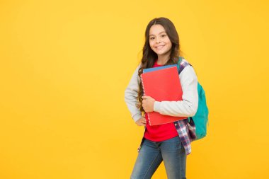 Sana ilham veren bir yer. Kütüphane okuyucusu sarı arka plan. Mutlu çocuk kütüphane kitaplarını tutuyor. Okul kütüphanesi. Okula dönen sevimli kitap kurdu. Bilgi ve bilgi. Bibliopol. Kitapçı, kopyalama alanı