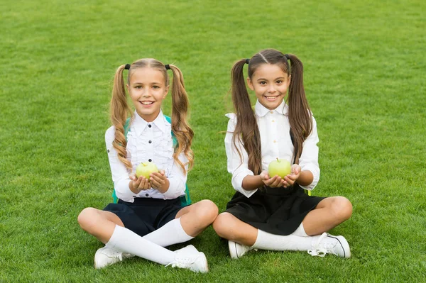 Szkoła studentów dziewcząt jedzących jabłka na lunch, koncepcja zdrowej żywności — Zdjęcie stockowe