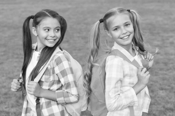 De volta à escola. Alunas giras com rabo de cavalo comprido. Fim do ano letivo. Alunas inteligentes e alegres. Boas alunas ao ar livre. Pequenas alunas com mochilas. Setembro. As férias acabaram. — Fotografia de Stock