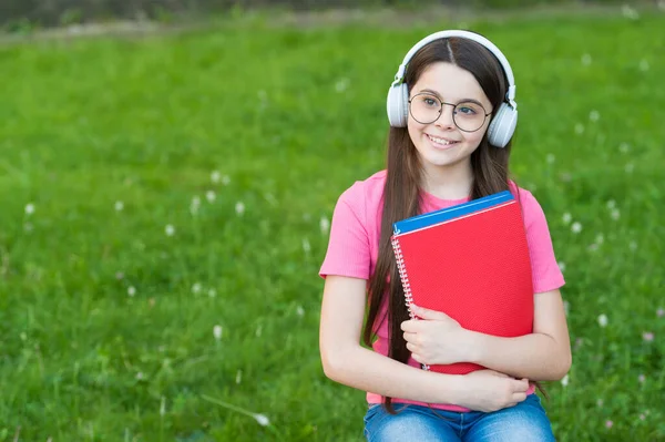 Menina ouvindo melodia de verão fones de ouvido sem fio natureza fundo, de volta ao conceito da escola — Fotografia de Stock
