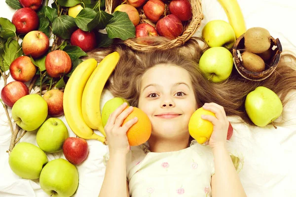 Μικρό χαρούμενο κορίτσι τρώει εξωτικά φρούτα ή καλοκαιρινό φόντο — Φωτογραφία Αρχείου