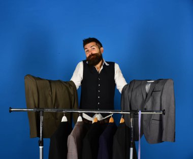 Tezgahtar elbise askılarının yanında seçim yapıyor..