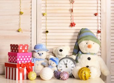 Kardan adamlar, oyuncak ayılar ve çalar saatin yanındaki kutular.