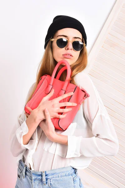 Леді тримає рожеву сумочку. Дівчинка в сонцезахисних окулярах з серйозним обличчям — стокове фото