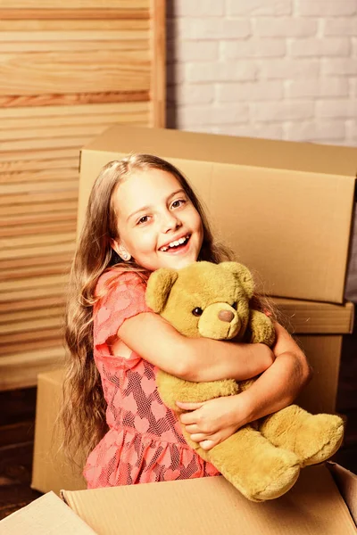 新的生活浪潮。快乐的孩子纸板箱。修理房间。新公寓。纸板箱-搬到新房子。快乐的小女孩，带着熊玩具。购买新住宅 — 图库照片