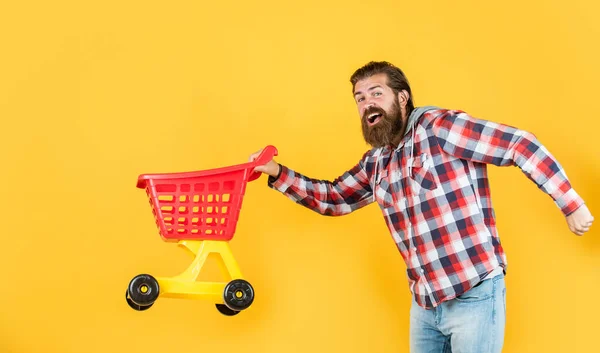 Dentro da loja. alegra compras bem sucedidas. brutal maduro hipster ir às compras. Está na hora de encher o carrinho. Vai às compras. homem engraçado com carrinho de compras pequeno. fim de semana na compra de produtos — Fotografia de Stock