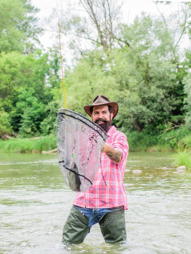 Fishermans Landing. mature man fly fishing. man catching fish. fisherman show fishing technique use rod. hobby and sport activity. Happy bearded fisher in water. summer weekend. Fly fishing