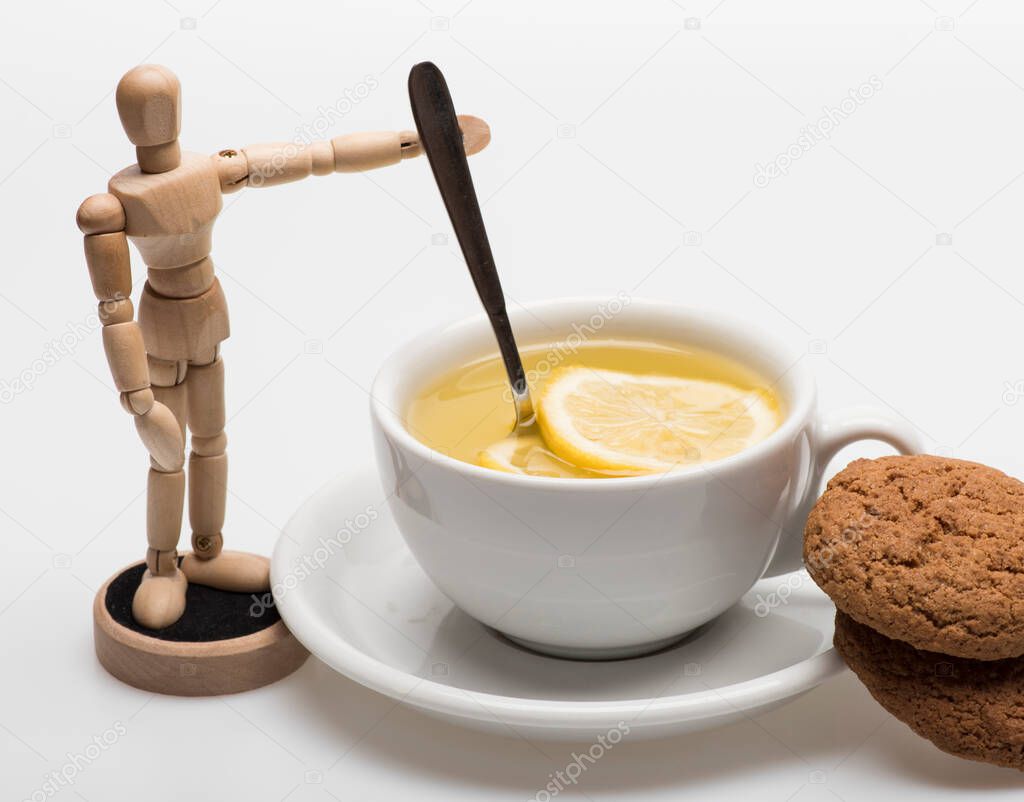 Tea cup with cookies and wooden toy on white background.