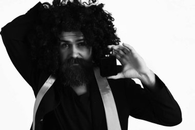 Takım elbiseli beyaz tenli hippi ve parfüm tutan siyah kıvırcık peruk