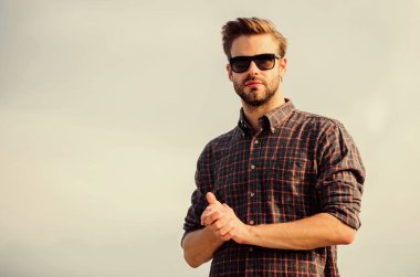 Erkek gözlüklü model açık havada mavi gökyüzü arka planı. Yakışıklı adam güneş gözlüğü takıyor. Moda güneş gözlüklü hippi. Ultraviyole koruma kavramı. Mükemmel görüş. Göz sağlığı. Moda güneş gözlüğü.