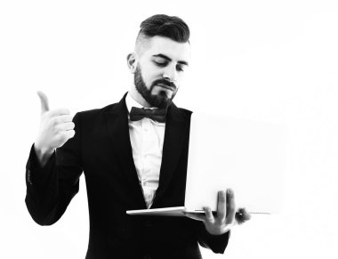 Bıyıklı sakallı iş adamı dizüstü bilgisayarı tutuyor ve onaylıyor.
