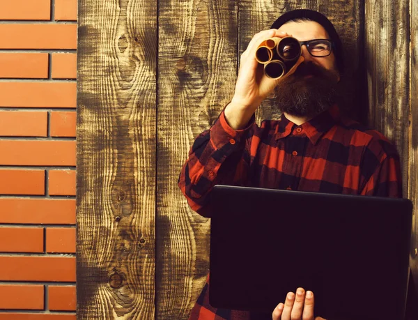 Skäggig brutal kaukasisk hipster med bärbar dator och hushållspapper — Stockfoto