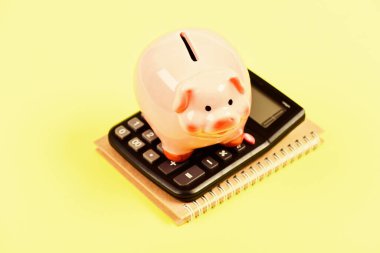 Vergi hesap makinesi. Muhasebe işi. Kumbaranın para tasarrufu sembolü. Yatırım konsepti. Domuz kumbarası ve hesap makinesi. Vergiler ve ücretler değişebilir. Akıllı finansal seçimler yapmaya yardım etmek. Vergileri öde