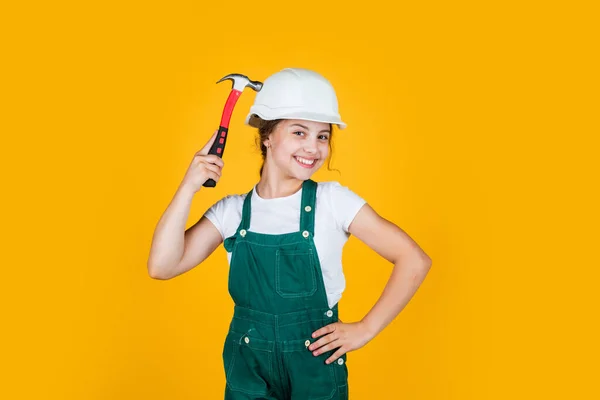 Håll dig säker. liten flicka reparera i verkstad. Glada unge i hjälmhammare. snickeri och träbearbetning koncept. tonårsbarn som använder hammarverktyg. Bygg- och reparationsverktyg. reparatör — Stockfoto