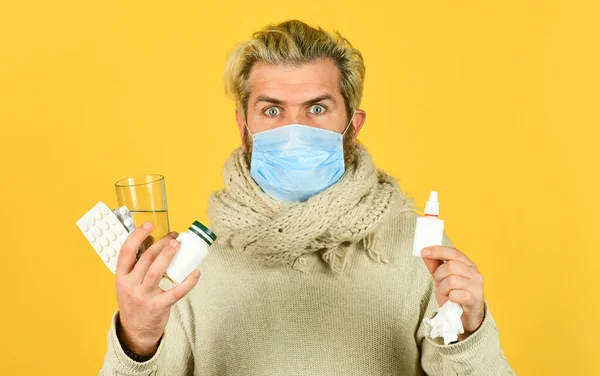Man bär andningsmask. hosta kyla och rinnande näsa botemedel. Man redo att ta ett piller. En sjuk man hemma. nysningar och hosta. Han har influensa och rinnande näsa. coronavirus från Kina — Stockfoto