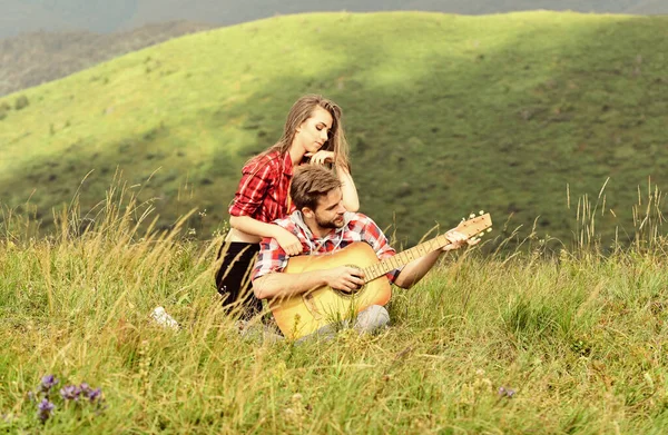 浪漫约会的理想地点。浪漫的心情。爱上你的夫妻在山顶上欣赏风景。男朋友在弹吉他。为她歌唱。浪漫的远足浪漫的情侣共度暑假 — 图库照片