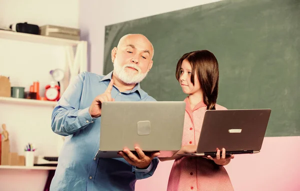 Leraar help schoolmeisje. Meisje met mannenbijles laptop vasthouden. Leerjongen. Internetcursussen. Moderne school. Docent digitale wetenschappen. Moderne pedagoog. Terug naar school. Online les — Stockfoto