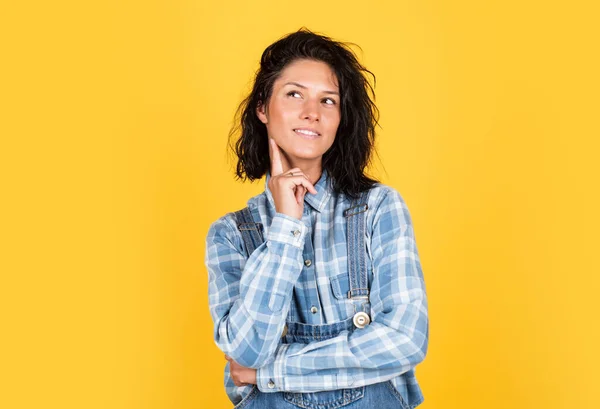 Lasst mich nachdenken. Mädchen auf gelbem Hintergrund. freudiges und charmantes Lächeln. Studentenmädchen denken. Modeporträt hübsche junge Frau. Hipster-Frau im karierten Hemd. Casual und Denim Trends — Stockfoto