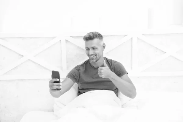 Modern life. Cellular communication. Communication technology. Self isolation and quarantine. Stay home. Morning. Online communication. Mature man use mobile phone in bed. Mobile communication