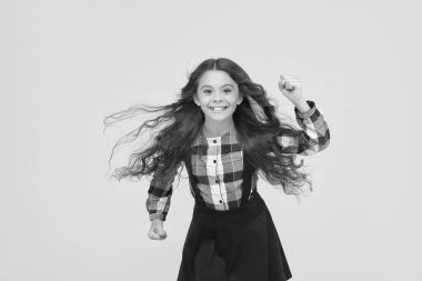 Koş bebek koş. Enerjik çocuk okula sarı arka planda koşuyor. Okula dönelim. Çocukluk aktivitesi. Eğitim ve kalkınma. Aktif yaşam tarzı. İçinden gelerek koş.