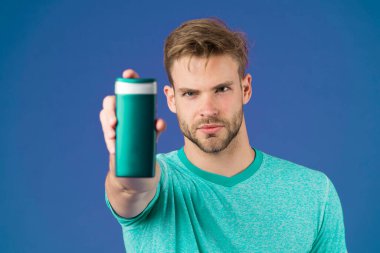 Sakallı adam plastik şişe tutuyor. Yakışıklı adam dış görünüşe önem verir kozmetik ya da hijyenik ürün kullanır. En sevdiği şampuanı ya da saç kremini göster. Şampuan şişesi en iyi seçenek.