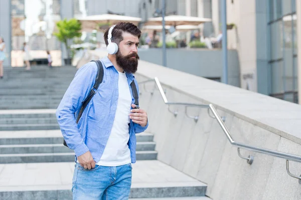 Route quotidienne vers le travail. La vie moderne. Changement de concept de décor. Beau hipster avec sac à dos rue de marche. Marcher dans des rues vides. Homme avec écouteurs marchant au centre-ville. Écouter de la musique — Photo