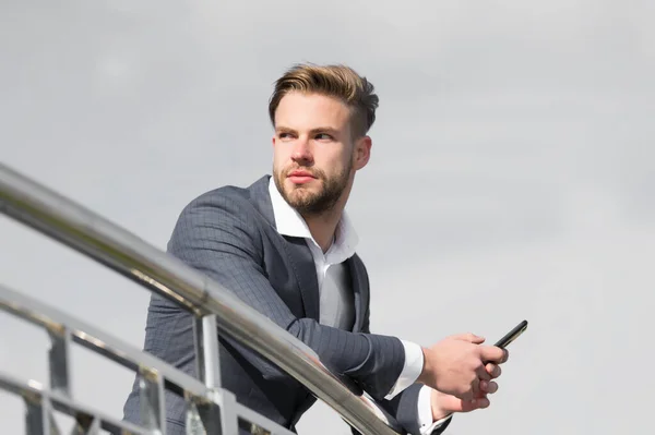 J'attends un appel important du partenaire. Homme d'affaires utiliser smartphone pour appel vidéo ou SMS fond ciel. Homme en costume homme d'affaires profite des technologies mobiles modernes pour les entreprises — Photo