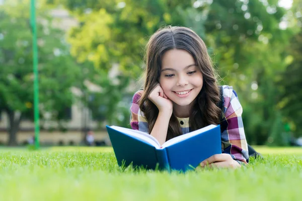 Om te slagen moet je lezen. Gelukkig kind las boek liggend op groen gras. Schoolbibliotheek. Geletterdheid onderwijs. Thuis lezen. Literatuurles. Vreemde taal leren. Engelse school. Tijd waard om door te brengen — Stockfoto