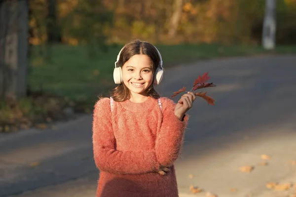 Magical moments start with music. Adorable girl enjoy music on autumn landscape. Cute little child listen to music playing in stereo headphones. Music education for small children