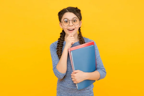 What a surprise. Surprised child hold books yellow background. Little girl open mouth with surprise. Small kid feel surprise. Surprising information. School library. Education and study. Big surprise — Stock Photo, Image