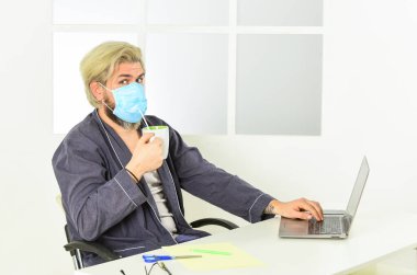 Uzaktan kumanda. Tıbbi maskeli bir işçi. Verimli bir gün için tek ihtiyacın olan bu. Tamamen korunuyor. Merkez ofis. Koronavirüsten korumak için maske takıyor. Maskeli adam pipetle çay içer. Çok hijyenik.