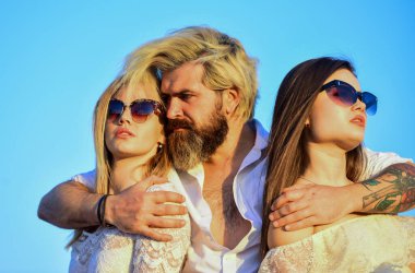 İkisine de aşığım. Çatıdaki partiden arkadaşlar. Havalı hipster ve kadın beyaz elbiseler. Kadınlar ve erkek arkadaşlar sarılıyor. - Aile. Yaz tatili. İlişkiler dostluk romantizmi. Üçlü konsept