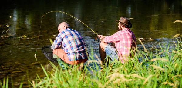 Samenhorigheid. Gelukkige vissers vriendschap. groot wild vissen. ontspannen op de natuur. Twee mannelijke vrienden die samen vissen. gepensioneerde vader en volwassen zoon met baard. vliegvissen hobby van mannen. uittredingsvisserij — Stockfoto