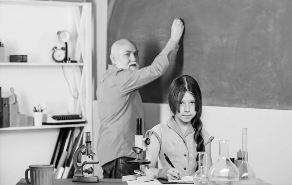 Lição de biologia fascinante. aula de ciências. Microscopia. Equipamento de laboratório. menina pequena com homem tutor estudar química. professor maduro de biologia. Aluna no laboratório da escola. usar lupa — Fotografia de Stock