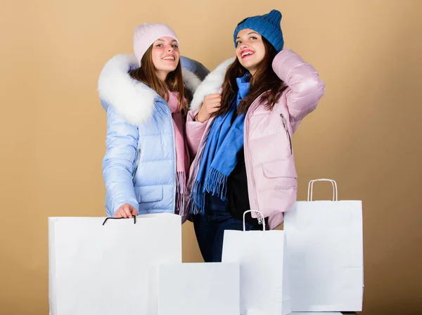 Eladó és kedvezmény. Női barátok vásárolnak téli ruhákat. Vásárlási útmutató. Műszőrme. Bevásárlótáska. Jól szórakozunk együtt. Fekete Péntek. Vegyél téli ruhákat. A lányok meleg kabátot viselnek. Vásárlási koncepció — Stock Fotó