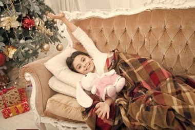 Noel arifesi. Noel mucizesini düşlüyordum. Noel hediyesini düşleyen küçük tatlı bir kız. Mutlu bir çocukluk. Küçük bir çocuk. Çocuk kanepeye uzanmış, Noel hediyesini düşlüyordu. Kış rüyası kavramı