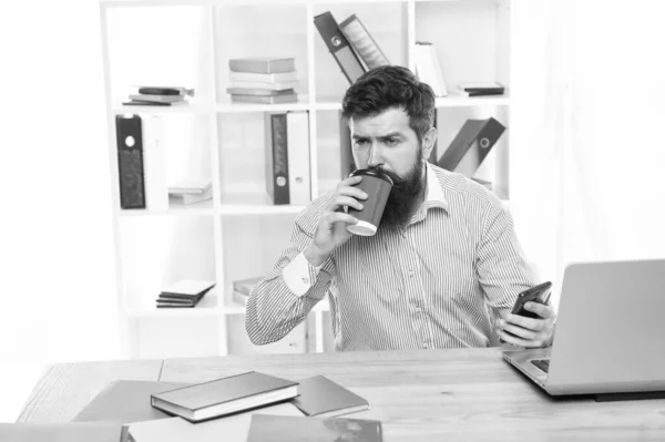 사무실로 배달 된 커피. 수염난 남자는 책상에서 커피를 마십니다. 직장의 사업가. 커피 맛이야. 현대 생활. 새로운 기술. 사업 통신. 새벽까지 커피를 마시고 일하라 — 스톡 사진