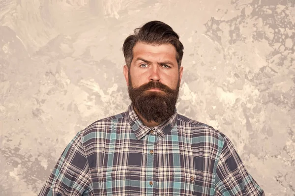 Masculine traits. Brutal bearded man concrete background. Serious man with beard and moustache. Confident hipster. Hairdresser in checkered shirt. Hipster style. Guy hipster outfit. Mature and trendy — Stock Photo, Image