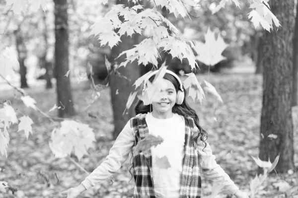 Mutlu ruh halinle yüzleş. Küçük çocuk sonbahar yapraklarıyla eğleniyor. Mutlu bir çocukluk. Mutlu küçük kız sonbahar parkında müzik dinler. Mutlu anlarını senkronize ediyorum